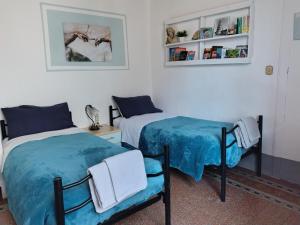 a bedroom with two beds and a chair at "LA MAISON DEL CORSO" Hospitality in Pisa