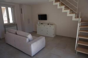 a living room with a white couch and a staircase at Residenza Diomedea in Vasto