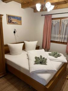 a bedroom with a bed with two plants on it at Tölgyfa Apartman in Balatonkeresztúr