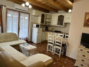 a living room with a couch and a kitchen at Tölgyfa Apartman in Balatonkeresztúr