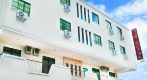 een wit gebouw met ramen en balkons erop bij Bay Hotel in Lahad Datu +33 foto's