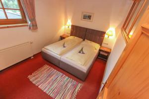 ein kleines Schlafzimmer mit einem Bett und einem Teppich in der Unterkunft Ferienhof Millinghof in Leogang
