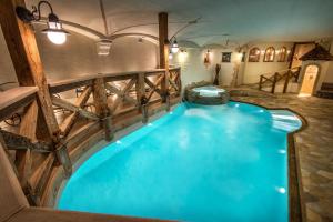 a large indoor swimming pool with a wooden fence and blue water at Hotel Gran Ciasa in Colfosco