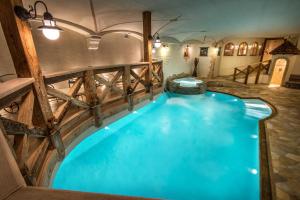 una grande piscina coperta con recinzione in legno e acqua blu di Hotel Gran Ciasa a Colfosco