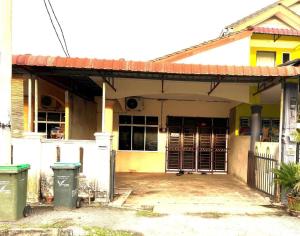 ein gelbes und weißes Haus mit Garage in der Unterkunft OYO Home 90492 Sena Homestay in Kampong Joo