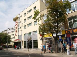 personas de pie en una esquina de la calle frente a un edificio en Hotel Blick, en Gdynia