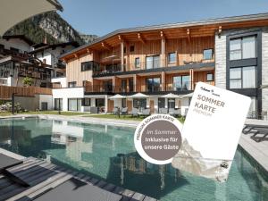 een bord naast een zwembad voor een gebouw bij Hotel Traube in Pettneu am Arlberg