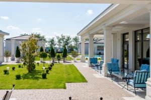 a patio with blue chairs and a lawn at J'adore Boutique Hotel in Lugoj