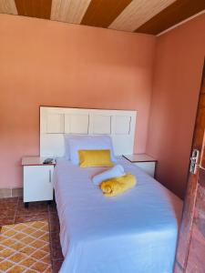 a bedroom with a large bed with two pillows on it at Star in Katima Mulilo