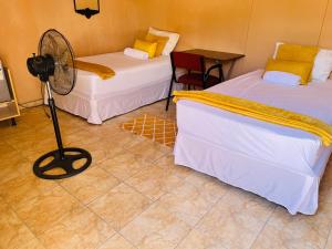 a room with two beds and a fan on the floor at Star in Katima Mulilo