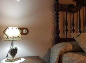 a lamp sitting on a table next to a bed at Habitació Doble Era de Ferro in Erill la Vall
