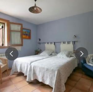 a bedroom with two beds in a room with two arrows pointing toorius at Habitació Doble Era de Ferro in Erill la Vall