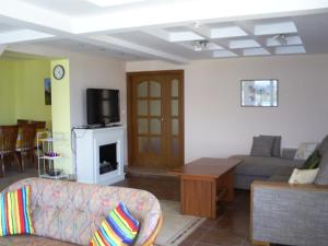 a living room with a couch and a tv at Villa Albena Bay View in Albena