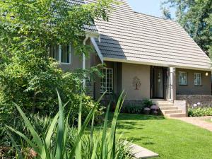 una casa con un cortile verde davanti di Wild Tree Lodge a Benoni