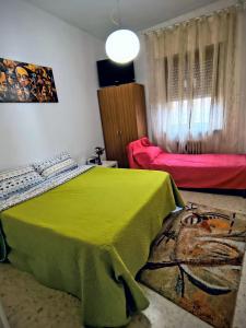 een slaapkamer met een bed met een groene sprei bij Ani in Porto SantʼElpidio