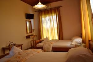 a hotel room with two beds and a window at Digenis Studios in Lygia
