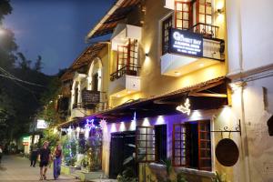 een groep mensen die 's nachts over straat lopen bij THE SUNSET BAY in Fort Kochi
