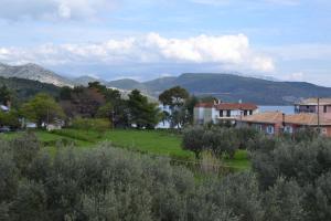 a house in a field with mountains in the background at Digenis Studios in Lygia