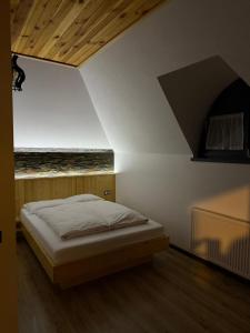 a bedroom with a bed in a room with a ceiling at Casa Bunicii in Şarul Dornei