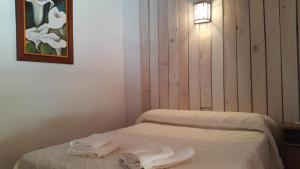 una stanza con un letto con asciugamani sopra di Albergue de Espiel a Espiel