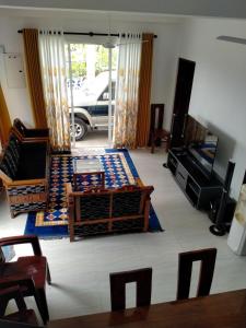 a living room with a couch and a tv at msm diamond villa in Ragama