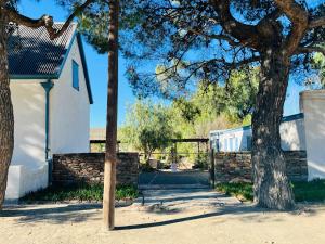 a white house with a gate and a tree at Sister Alice in Nieu-Bethesda
