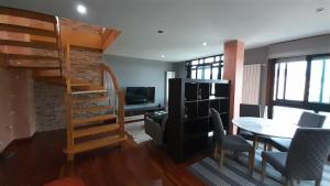 a living room with a loft bed and a table at Ameli House By PECA in Silleda