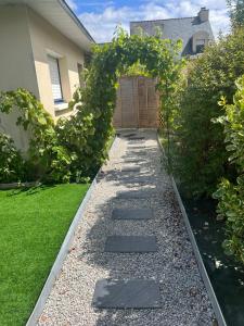 a garden with a pebble walkway and an arbor at Studio maisonnette Caudan in Caudan +3 photos