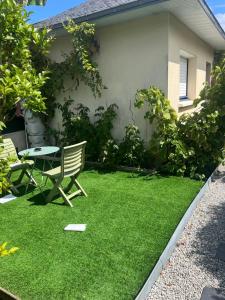 a lawn with a bench and a table in a yard at Studio maisonnette Caudan in Caudan