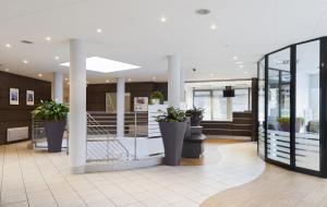 a lobby with potted plants in a building at Zenitude Hôtel-Résidences Les Hauts d'Annecy in Annecy