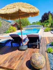 a patio with an umbrella and a swimming pool at Petite parenthèse au gîte Layon in Les Garennes sur Loire