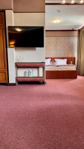 een hotelkamer met een bed en een flatscreen-tv bij Спа Хотел Орфей in Devin