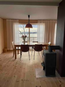 a dining room with a table and chairs and a window at Lofoten Seaside House in Offersøya +6 photos
