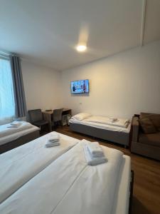 a room with three beds and a couch and a tv at Hotel Vogelweiderhof in Salzburg +29 photos