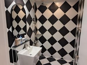 een badkamer met een zwart-wit geblokte muur bij 그랑메종바오밥호텔 in Samgong-ni