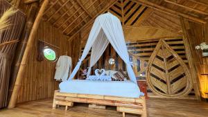 a bedroom with a bed in a wooden room at Wana Bamboo House by ecobreeze in Sidemen