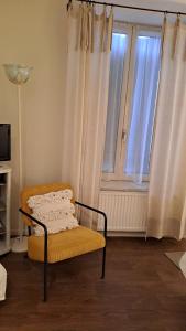 una sedia seduta davanti a una finestra con tende di eurl l'ABRICOTIER a Saint-Macaire