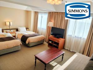 una camera d'albergo con due letti e una TV a schermo piatto di Grand Hotel Kanachu Hiratsuka a Hiratsuka Altre 52 foto