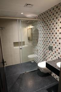 een badkamer met een douche, een toilet en een wastafel bij THE SUNSET BAY in Fort Kochi +15 foto's