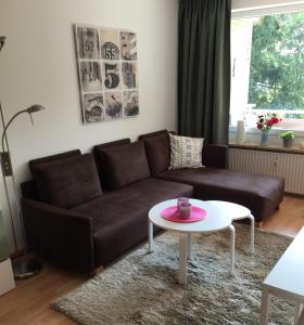 ein Wohnzimmer mit einem braunen Sofa und einem Tisch in der Unterkunft Feriendomizil Mien Droom in Timmendorfer Strand