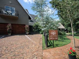 una casa con un cartello di fronte a un vialetto di mattoni di Wild Tree Lodge a Benoni Altre 3 foto