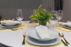 una mesa con platos y tenedores y copas de vino en Bracara Guest House "Arco", en Braga