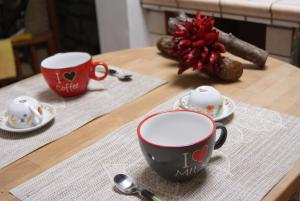 BareteにあるLa Baita Baretanaのコーヒーカップ2杯とソーサー付きのテーブル