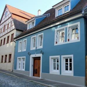 ein blaues Gebäude auf einer Straße in einer Stadt in der Unterkunft Ferienwohnung Muss - Rothenburg in Rothenburg ob der Tauber