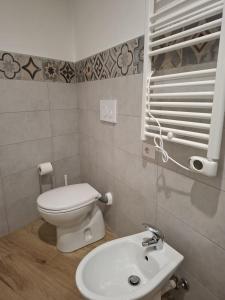 a bathroom with a white toilet and a sink at Monolocale Corbetta centro - House lab Milan in Corbetta