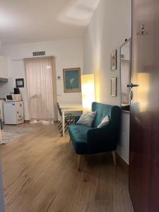 a living room with a green couch and a table at Monolocale Corbetta centro - House lab Milan in Corbetta