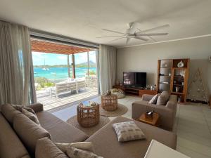a living room with a view of the ocean at Turquoise Bay Beach Apartments Trou d'Eau Douce in Trou d'Eau Douce
