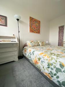 een slaapkamer met een bed, een dressoir en een lamp bij Bed and Breakfast Nantes au calme proche aéroport, gare et centre-ville in Saint-Sébastien-sur-Loire