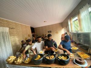 een groep mensen die rond een tafel met eten staan bij Pousada Jalapão Rosa do deserto in Mateiros +35 foto's