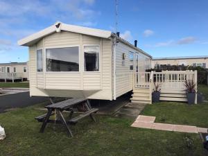 a white tiny house sitting on top of a bench at Lyons Robin Hood Rhyl North wales six berth caravan choice of two available in Meliden